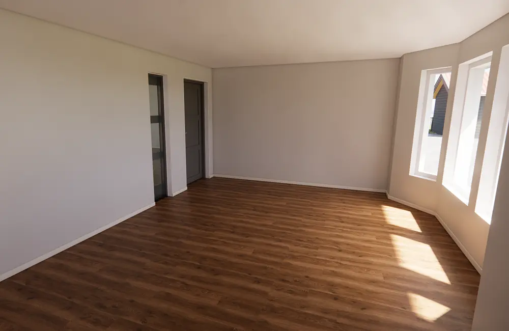 Rum med vita väggar, träparkett och fönster.