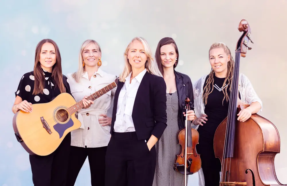 Fem kvinnor där tre av dem håller i instrument.