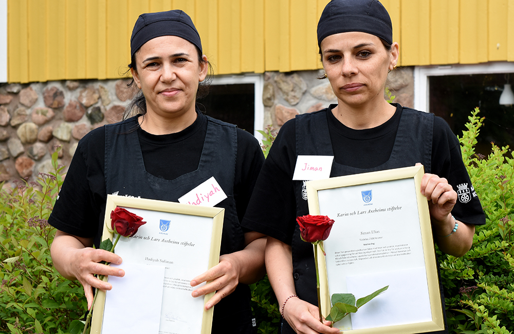 Porträttbild på Hadiyah Suliman och Jiman Elias som håller i sina diplom och rosor.