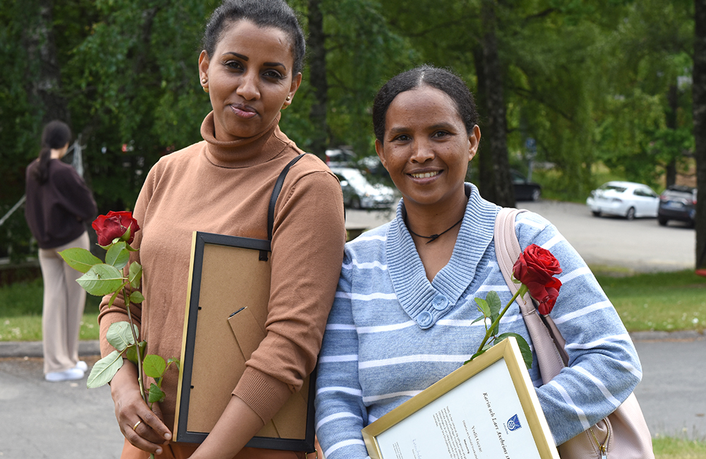 Bild på Nazret Gebremehdin och Yodit Gezea som har diplom och blommor i händerna.