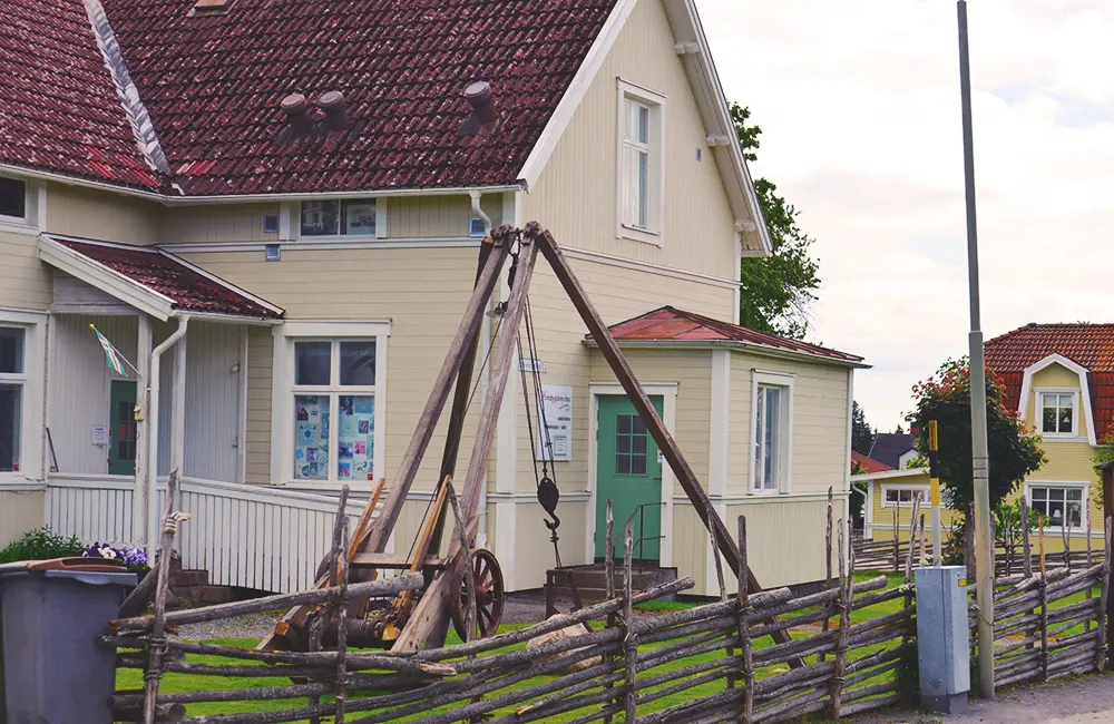 Sandsjö hembygdsgård, stort gult hus omgivet av gärdsgård.