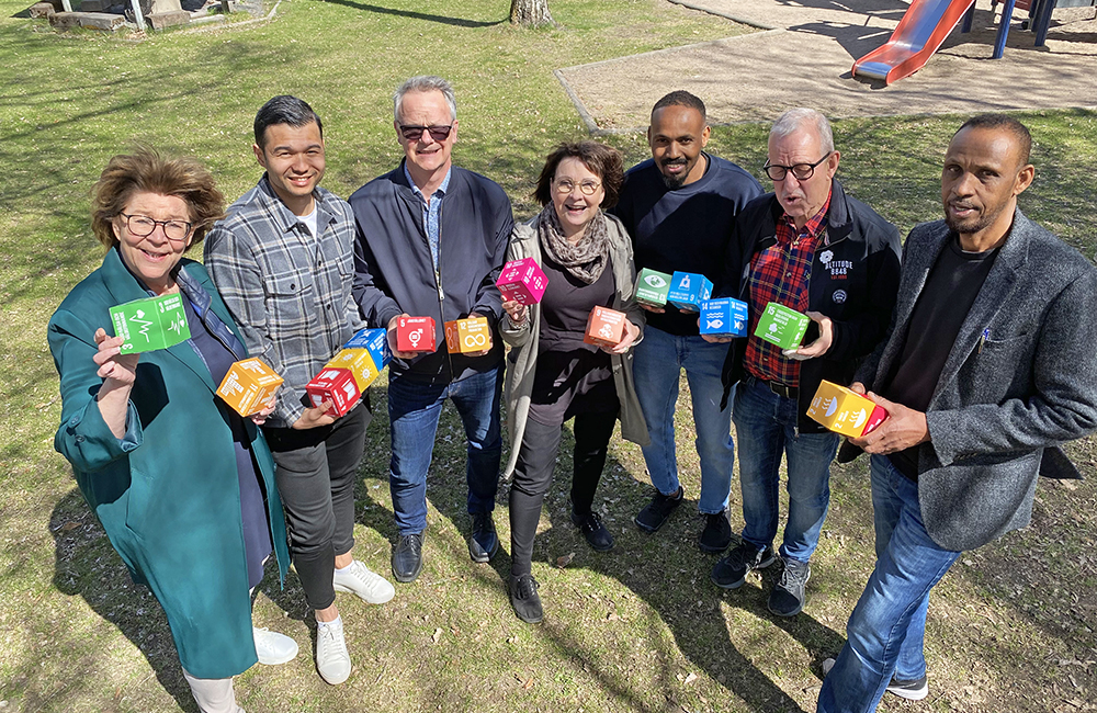 Sju kollegor på Nässjö Lärcenter håller i färgglada kuber med de globala målen.