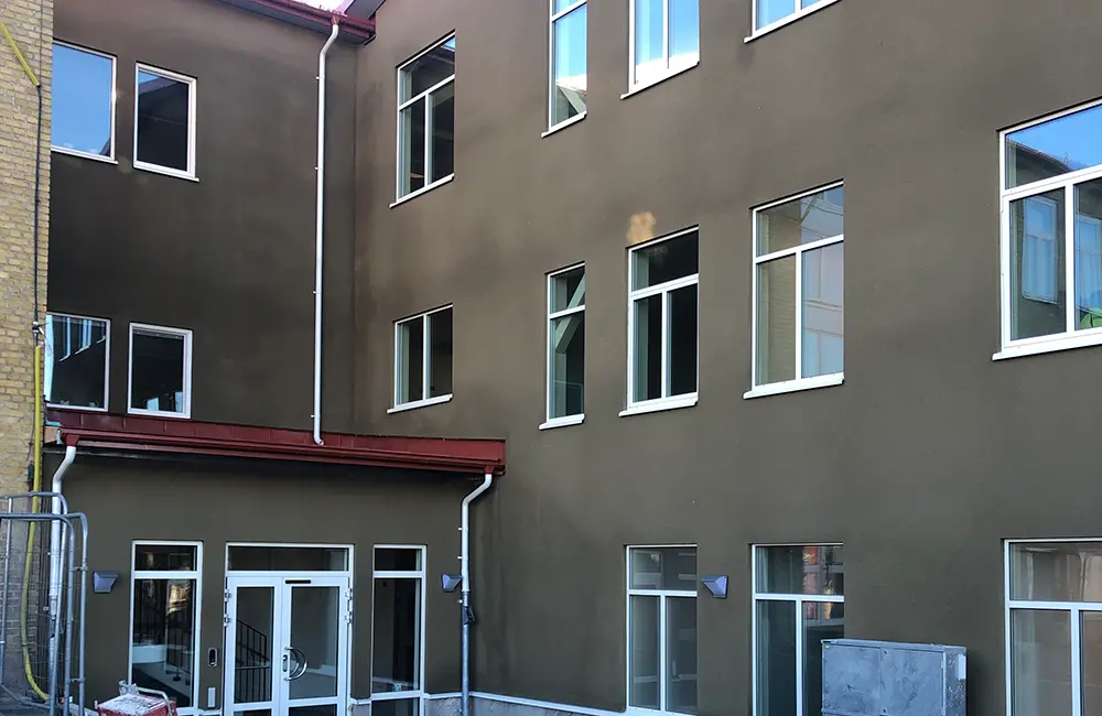 Fasad utifrån med fönster och entré.