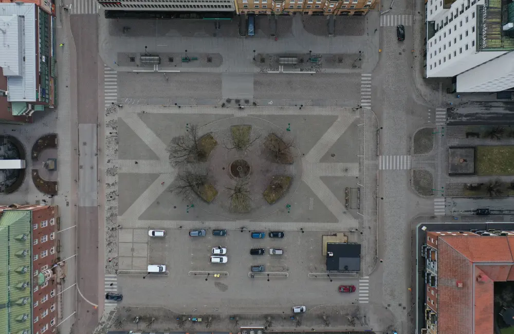 Bild som visar planområdet från ovan. Bilder visar torg, gator, byggnader, träd och bilar