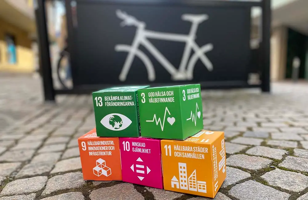 Kuber med de globala målen står i en pyramid framför ett cykelställ i Nässjö.