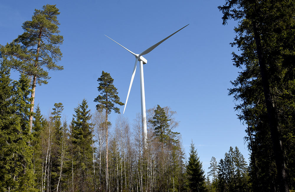 Bild på vindkraftverk i skog med texten ansökan öppen.