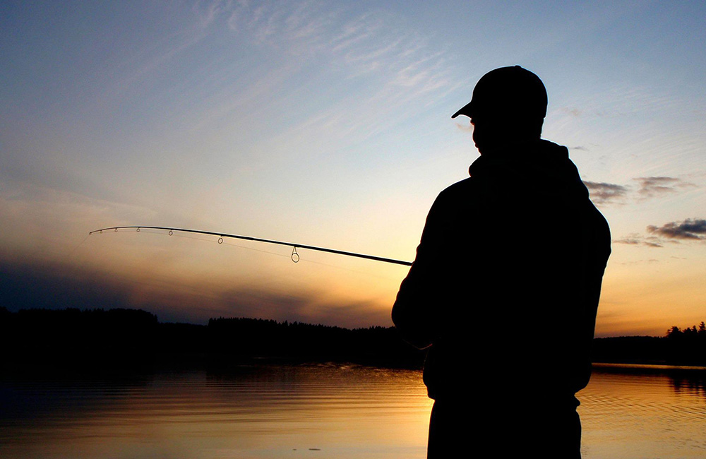 Man som fiskar i solnedgången