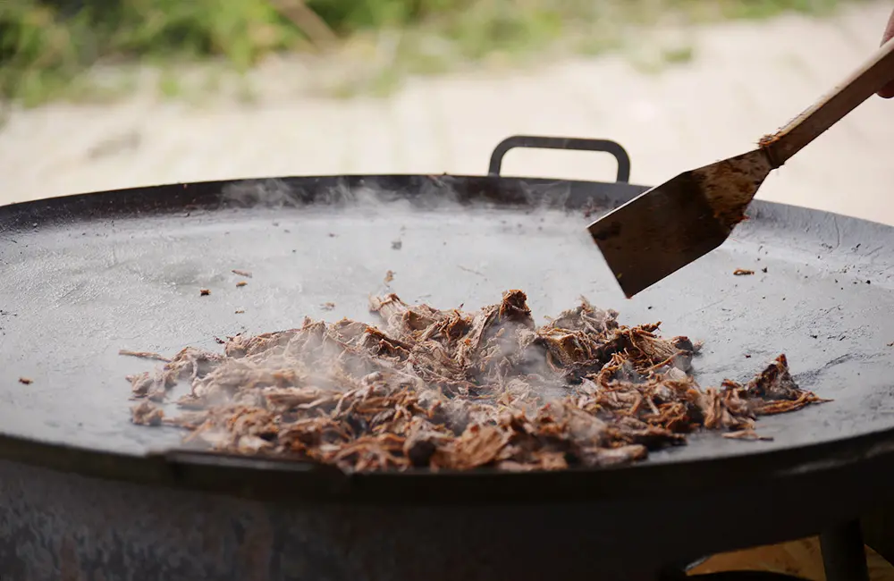 Pulled beef tillagas på en stor muurikka.