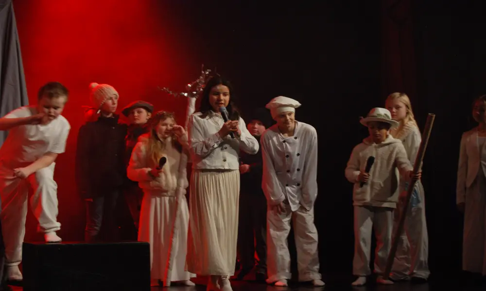 Flera av barnen står på scenen och agerar.