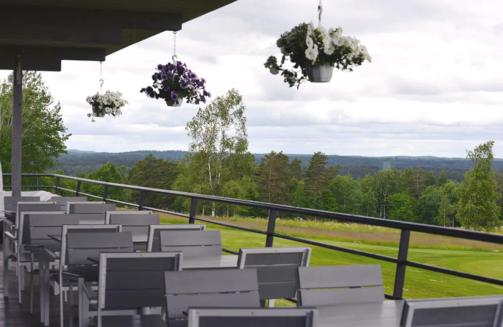 Uteservering på Nässjö Golfrestaurang med utsikt över golfbanor och böljande landskap i horisonten.