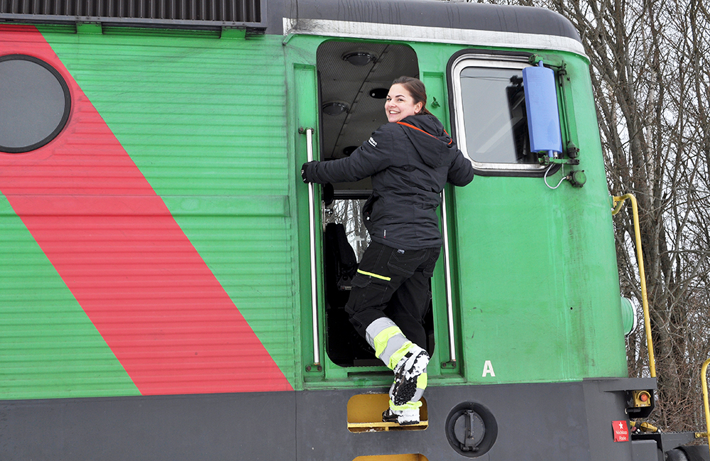 Petra Thorsén som är lokförare klättrar upp i lokförarhytten.