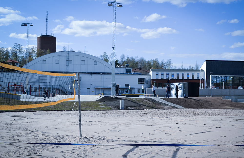 Bild på idrottsanläggning med sandplan och volleybollnät.