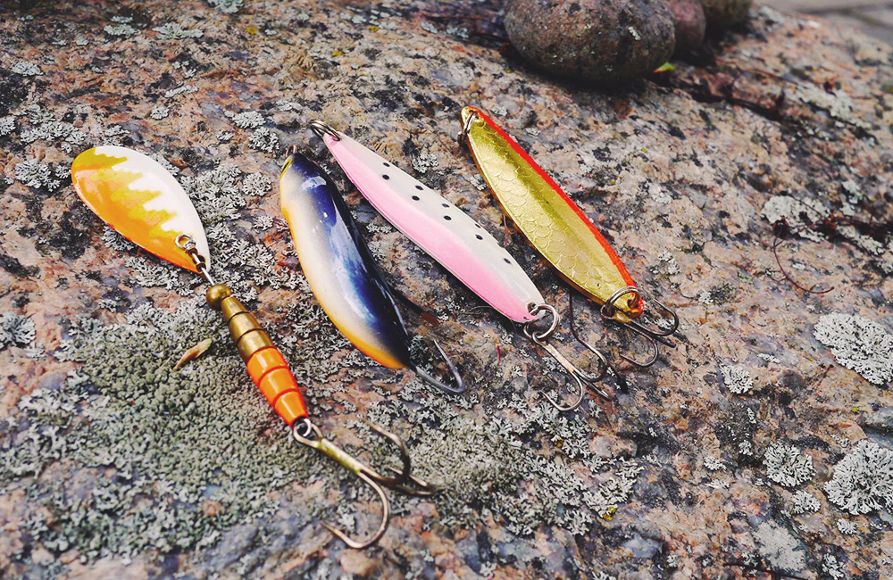 Fyra fiskedrag ligger på en sten