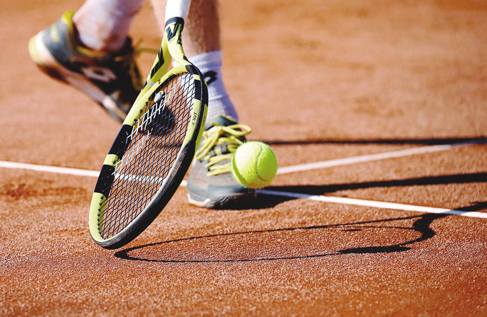 Tennisracket studsar tennisboll mot tennisplan