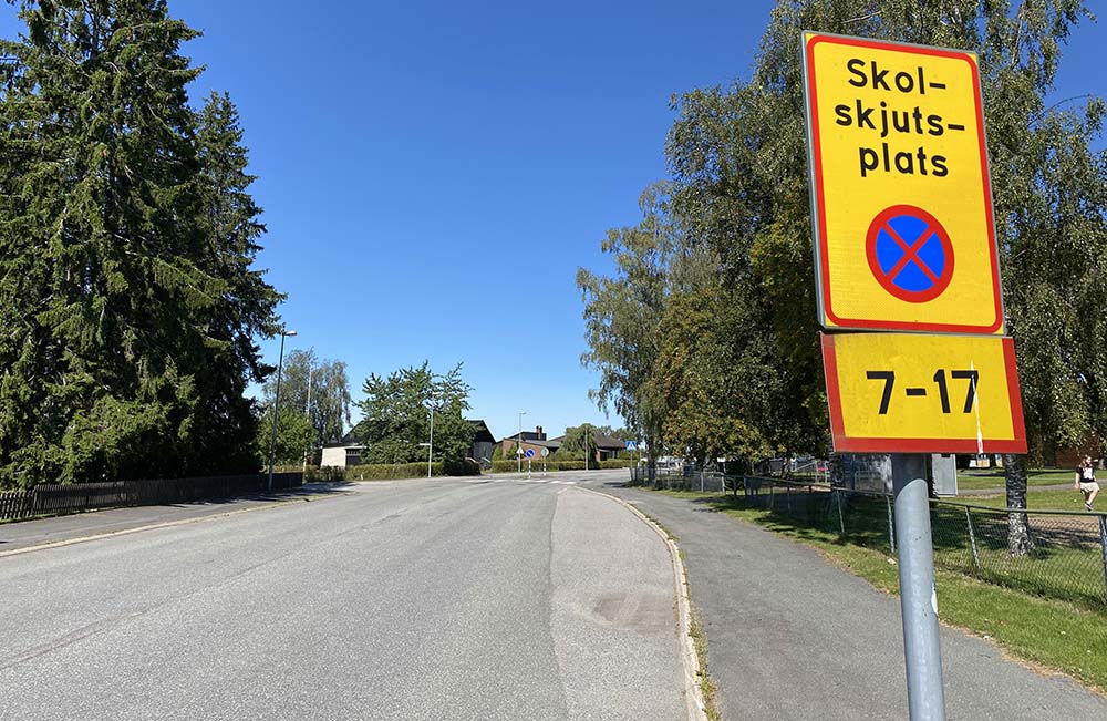 En vägskylt intill en busshållplats visar texten Skolskjutsplats, parkeringsförbud kl. 7-17.