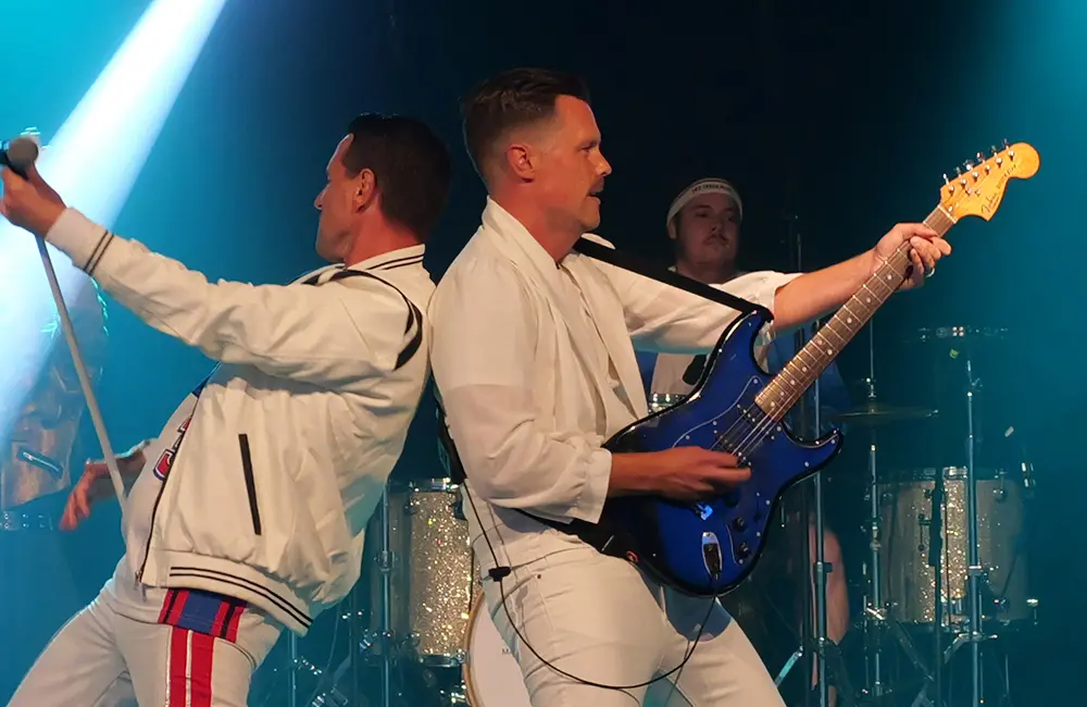 Tre män och en utklädd person.