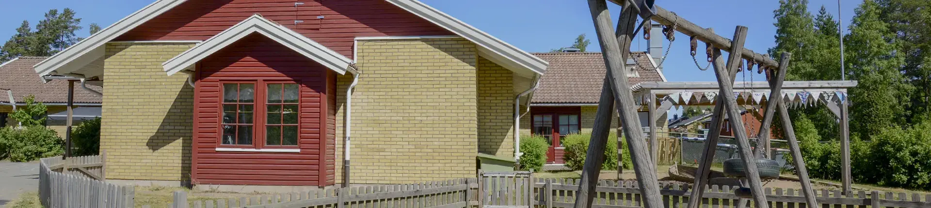 Byggnad i gult tegel och röda detaljer runt fönster.