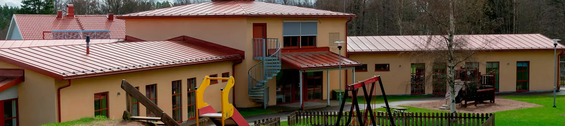 Byggnad med gult fasadtegel och rött tak.